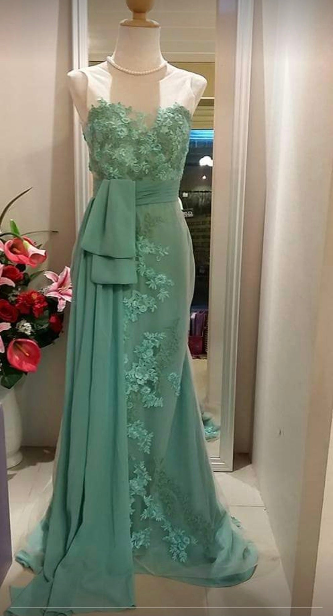 Mint green long evening dress with embroidered flowers and a draped front