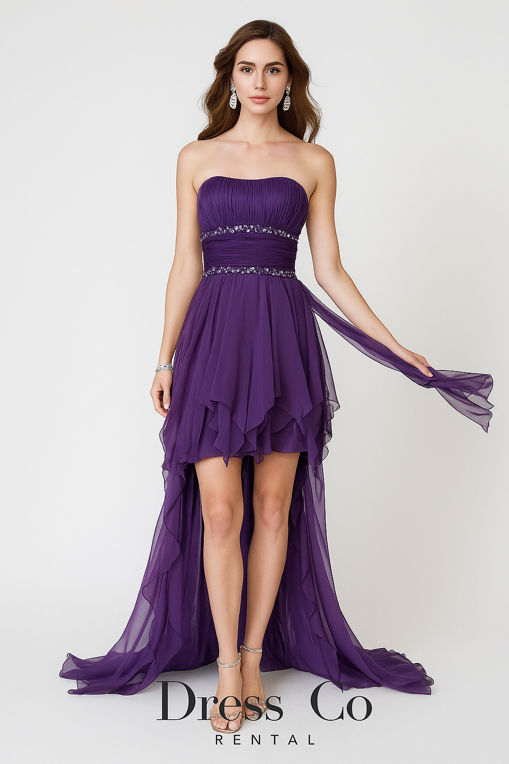 Purple strapless high-low evening dress with crystal embellishments and a long ruffled hem.