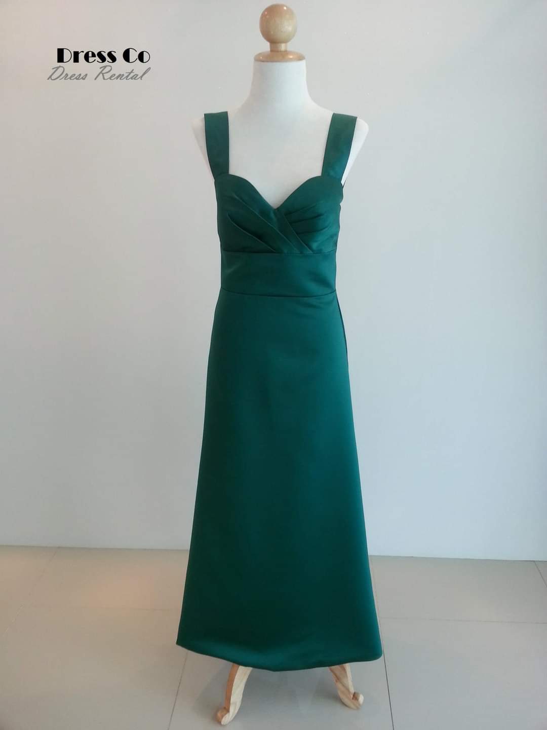 Dark green long dress with thick straps, crisscross design, slim fit.